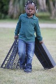 Zariah Green carries boxes across the Marshview Community Organic Farm in order to harvest the greens planted.